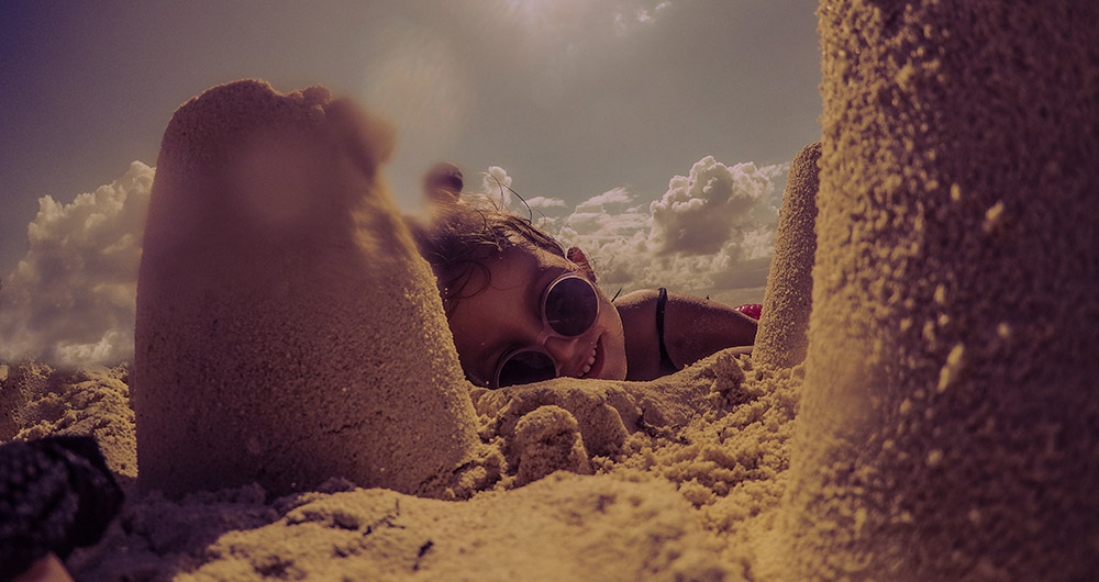 A child playing in the sand at the beach