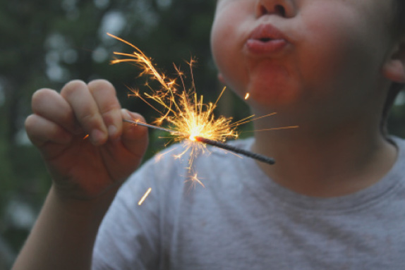 Surrogate toddler blowing on sparkler