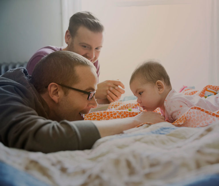 Two fathers with their baby