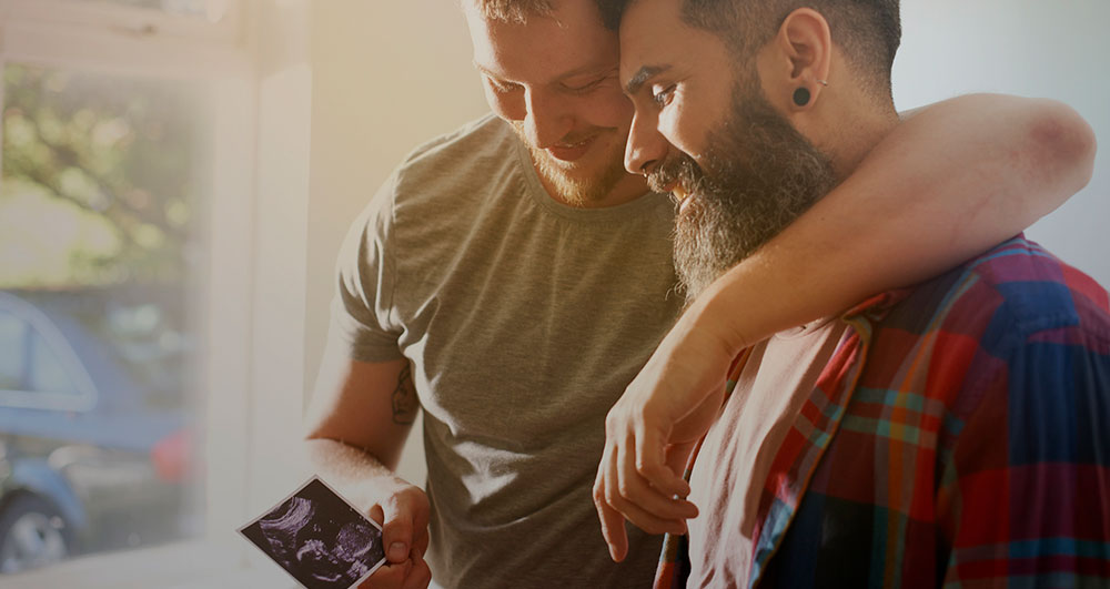 Two expectant fathers looking at an ultrasound photo