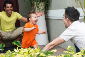 Two fathers playing with their toddler